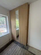 3 door wardrobes with a mirrored shaker door in the middle in Farerra Oak (angled view), fitted in Norton